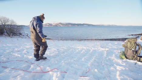 Man-Leveling-The-Snow-On-Ground-With-His-Feet-For-Camping-Tent