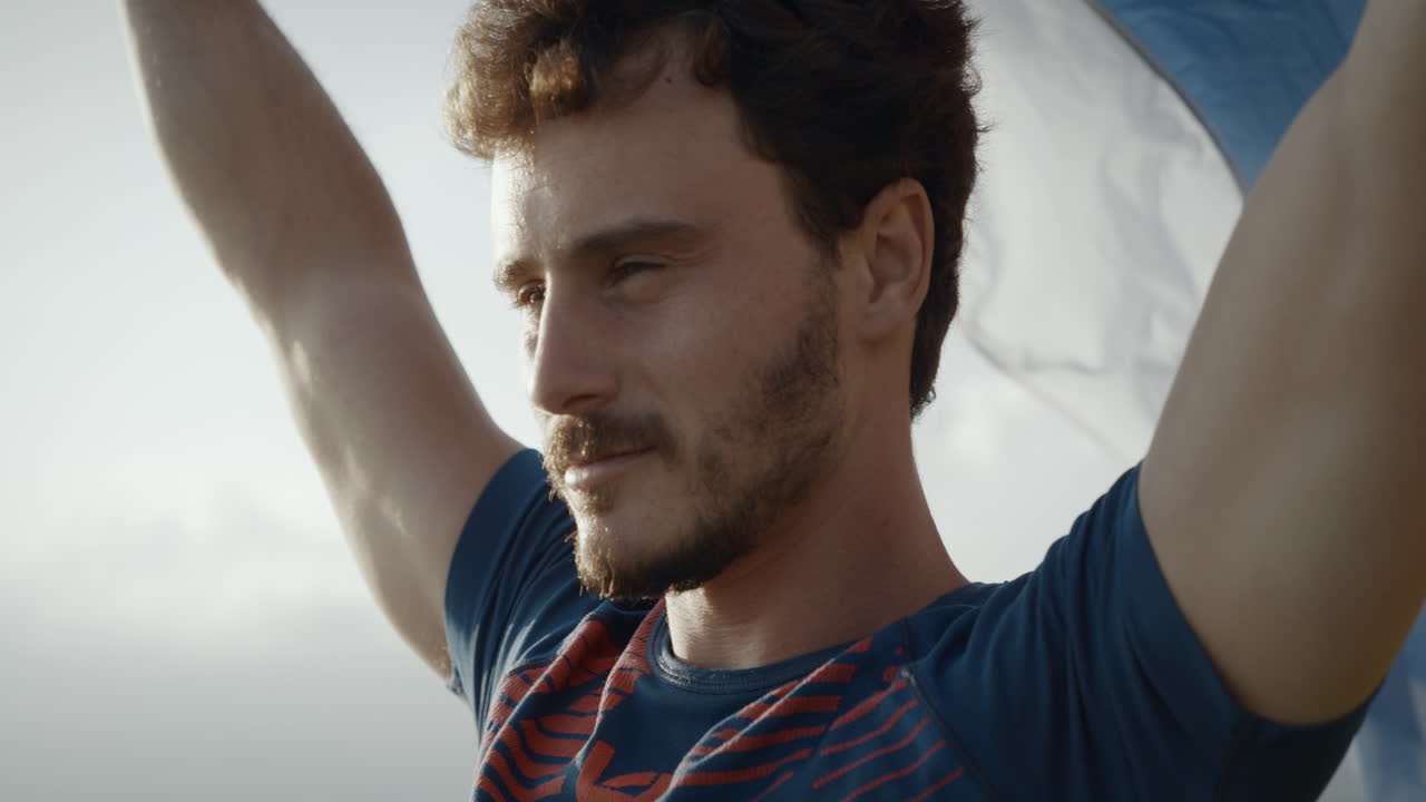 슬로베니아 호모를 들고 바람에 펄럭이는 젊은 남자의 클로즈업