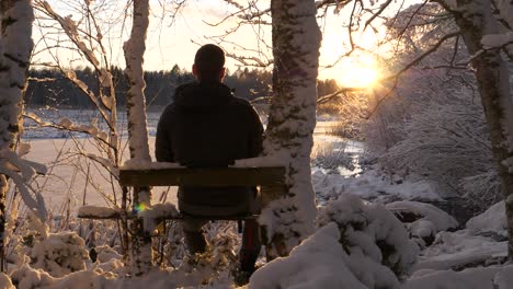 hombre disfrutando de la vista del país de las maravillas del invierno, árboles helados al atardecer dorado