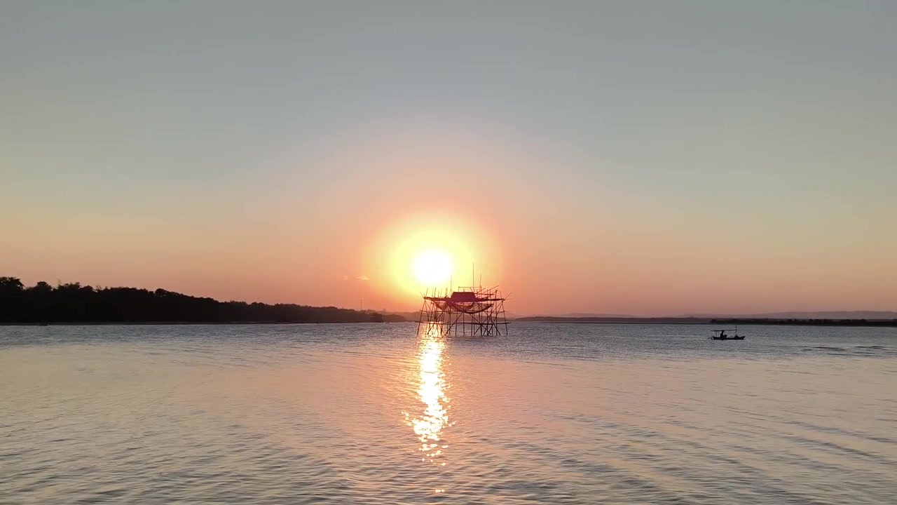 Pôr do Sol Sobre Lago Calmo Com Estrutura de Pesca Tradicional