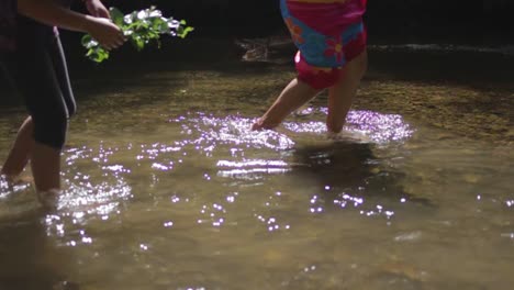 two woman are walking in a shallow river