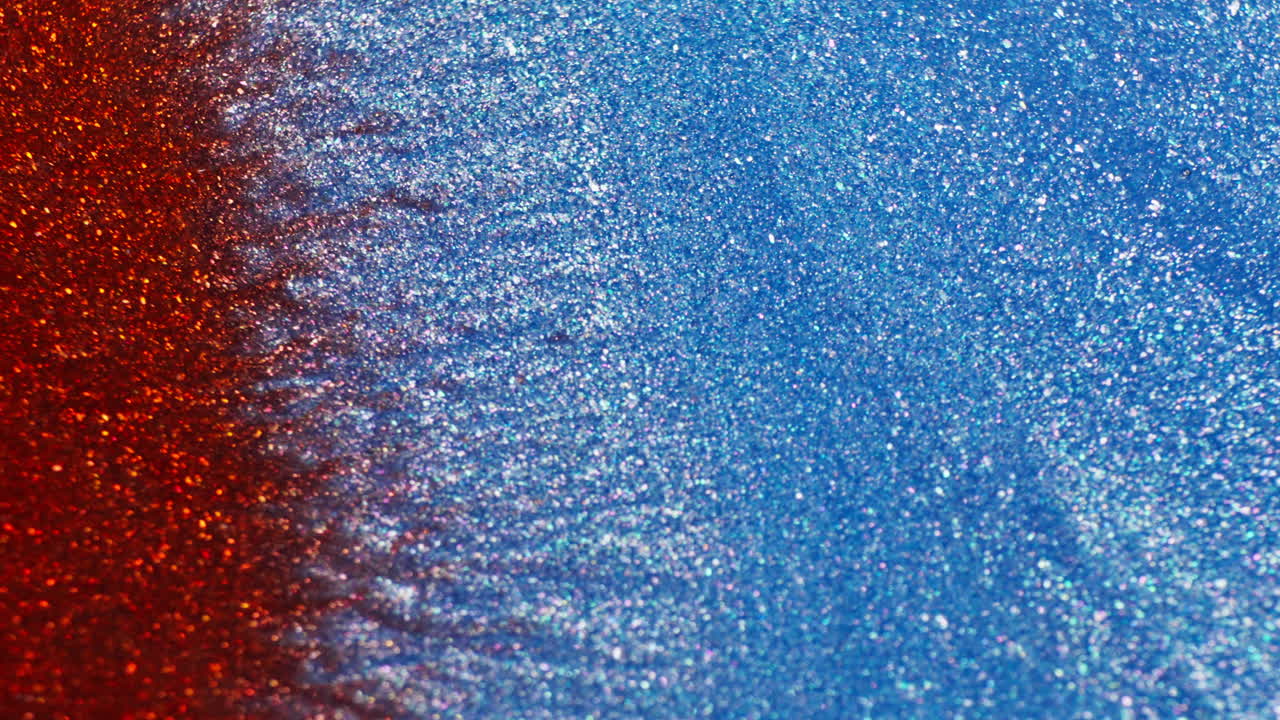 Dense ink with glitter moving in waves. Macro view
