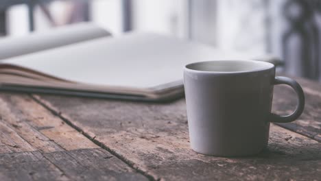 hot steaming coffee-tea mug with book on the wooden table for studying and relaxing