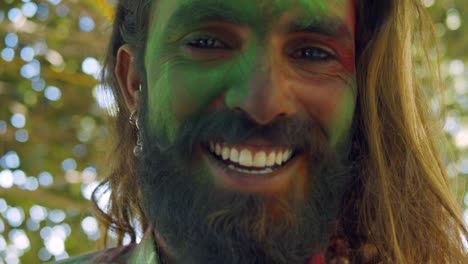 indian man close-up of face smeared with bright holi colors