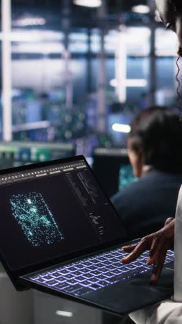vertical video close up of data center technician using tablet to monitor neural network ai llm