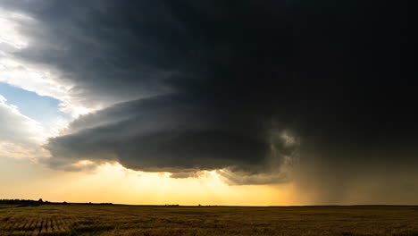 supercell storm over a field at sunset