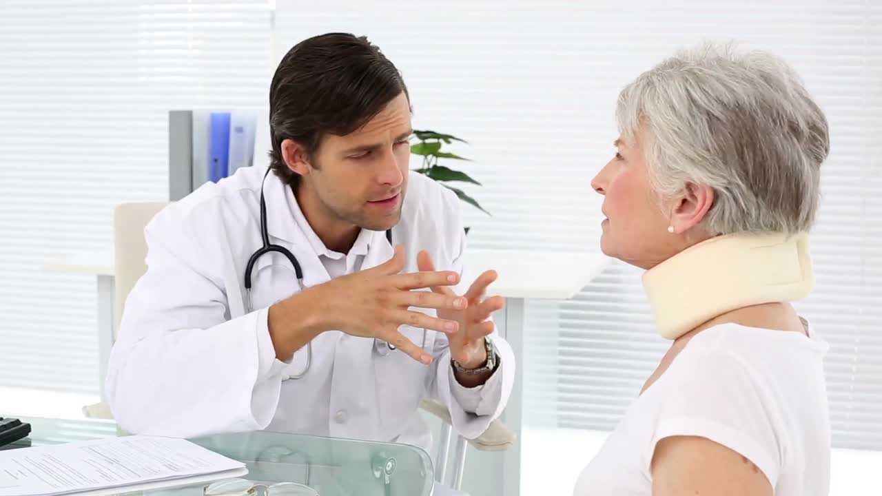 el médico está revisando a un paciente jubilado con correa para el cuello.