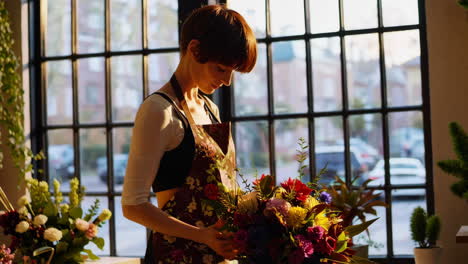 florist arranging a colorful bouquet by a window