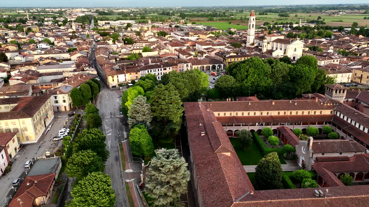Drone pull-out from Castello di Pontevico along the Oglio River, with the town’s historic center and countryside unfolding in the background