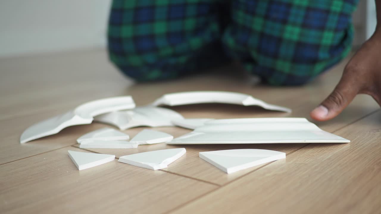 Person arranging broken plate shards