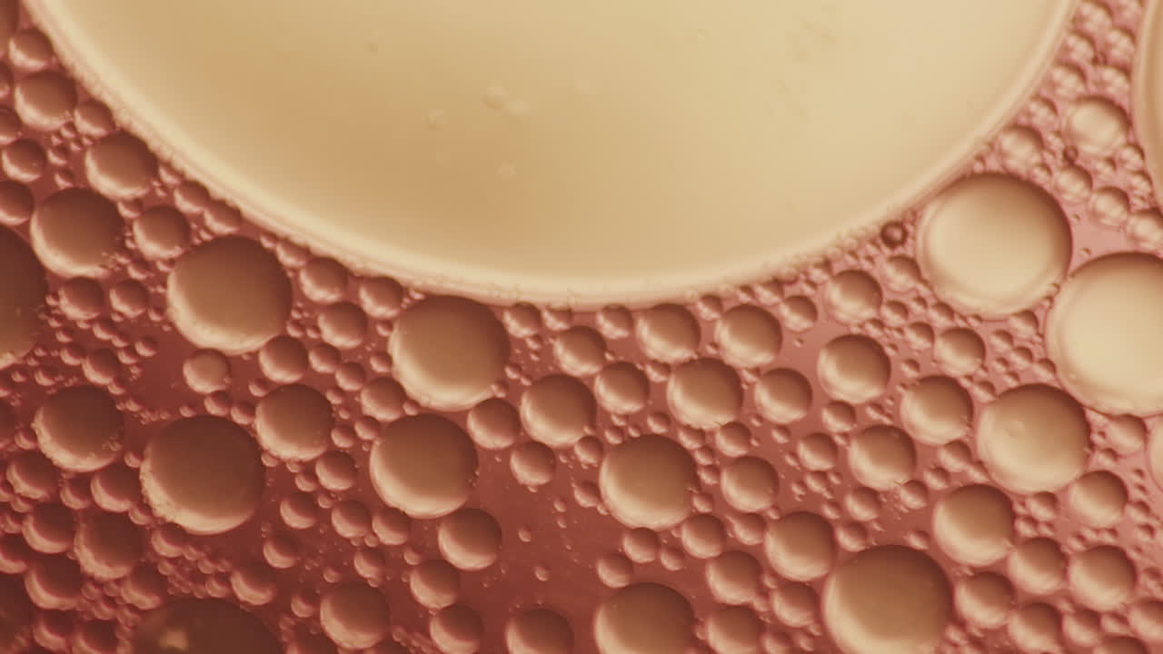 점성 호박색 액체에서 움직이는 작은 거품의 매크로 샷