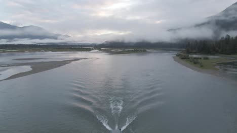 4K-Drone-footage-of-a-jet-boat-moving-down-river-center-frame