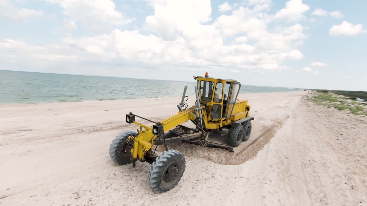 해변 에서 일 하는 노란색 발굴기