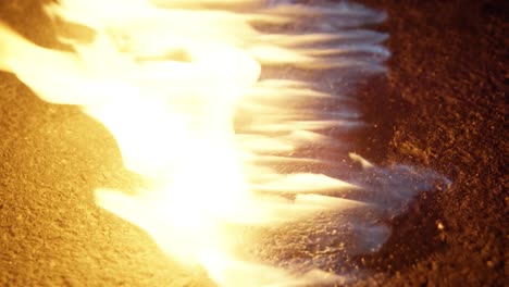 Close-up-shot-of-a-flame-on-the-ground---on-a-road---street-at-night-25p