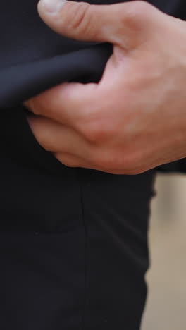 gentleman in black office suit puts hand into pocket standing by pine tree in park closeup slow motion. stylish businessman rests after work in nature