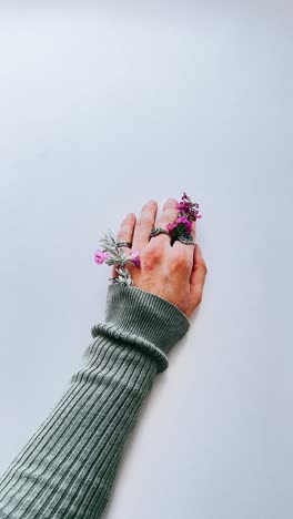 mano con flores y anillos