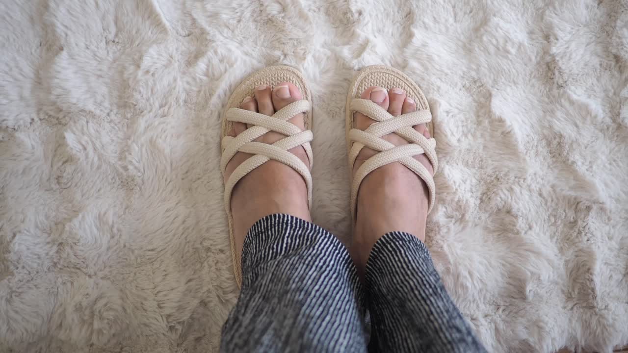 Piedi con i sandali su un tappeto