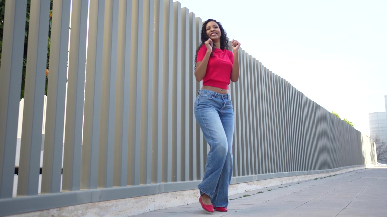 Una giovane donna elegante che posa con sicurezza all'aperto con un outfit alla moda e di tendenza