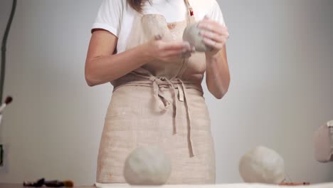 mujer moldeando arcilla en el estudio de cerámica