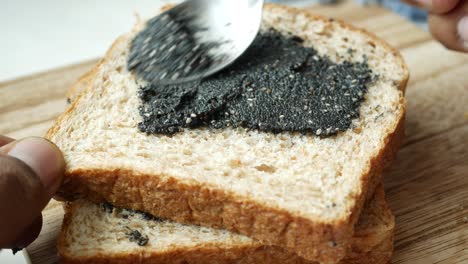 preparing a sesame seed spread on whole wheat bread