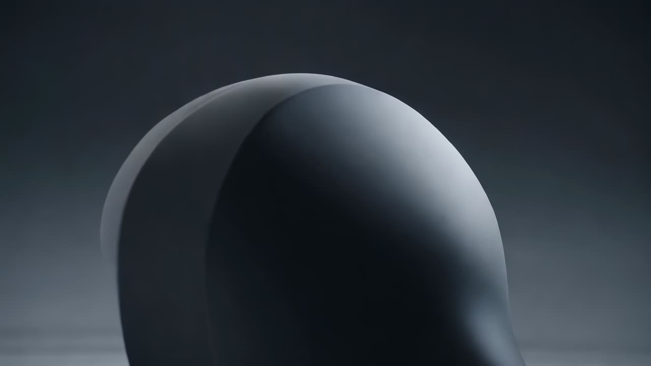 Zoom della camera che rivela un unico guscio arrotondato liscio grigio scuro in studio, che mostra l'apertura incassata