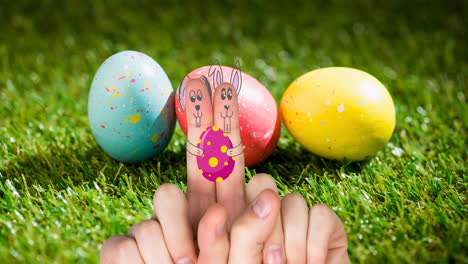 animación de manos con dibujos de conejo con huevo de pascua sobre huevos de pascua en la hierba