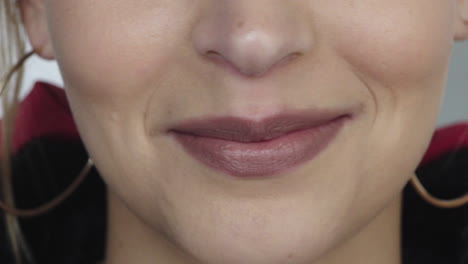 cerrar la boca de una joven mujer caucásica sonriendo satisfacción feliz dientes blancos saludables concepto de salud dental el uso de pendientes