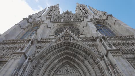 ornate stone facade and large wooden doors of votive church in vienna, austria