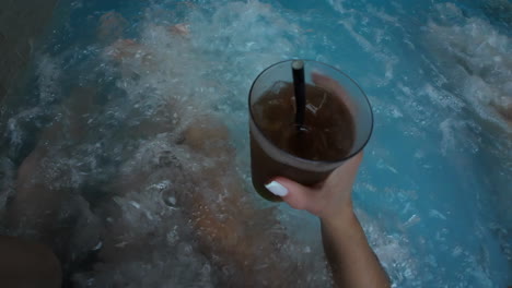 pareja relajándose en el spa jacuzzi con bebida de cola oscura en la mano centro de relajación