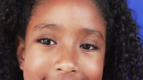 close-up of a biracial girl with curly hair and a subtle smile