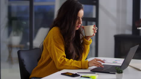 Fokussierte-Geschäftsfrau,-Die-Im-Büro-Am-Laptop-Arbeitet.-Hübsche-Frau,-Die-Tee-Trinkt