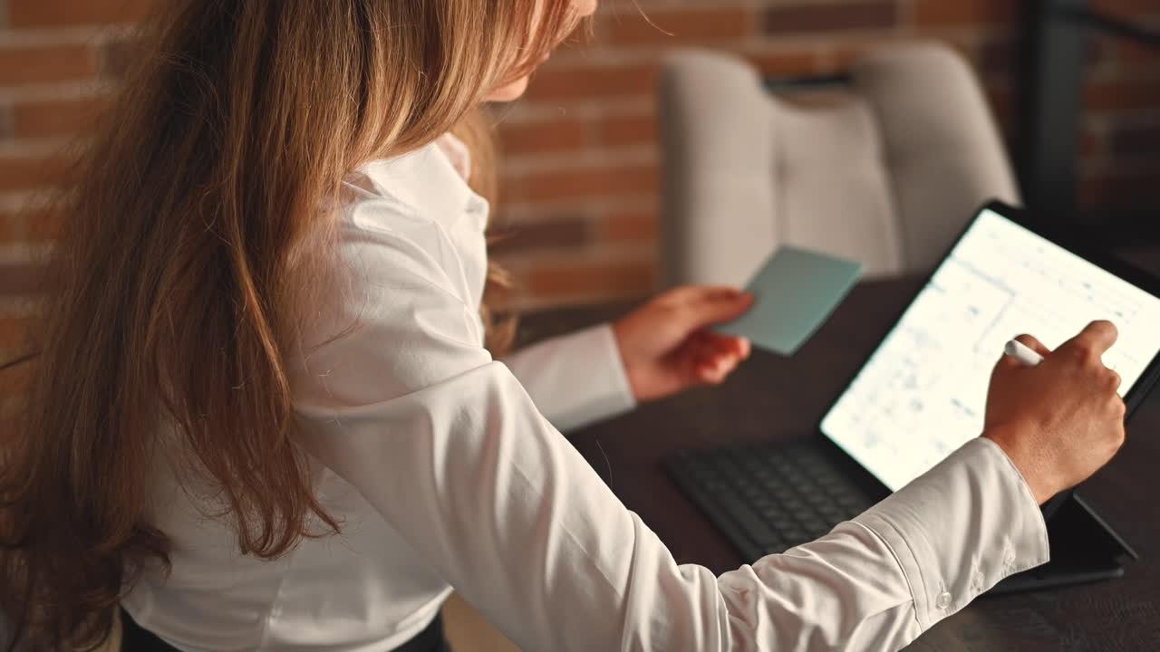 Woman working on a tablet with a stylus pen at an office