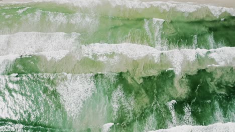 drone shot of foamy waves forming and breaking on a loop