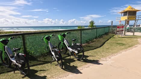 bicycles parked near a beachside fence