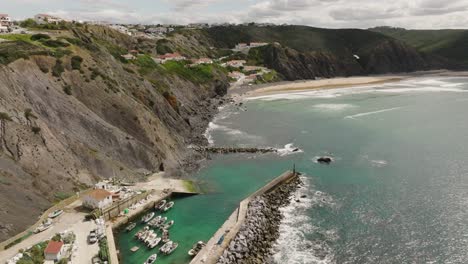 aerial shot flying over a small, secluded marina towards a beautiful beach at high tide