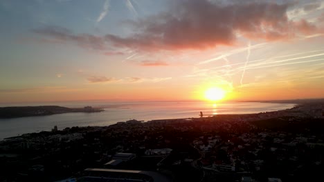captivating aerial perspective: sunset paints the ocean's horizon, with a coastal city in the foreground, creating a spectacular and serene tableau
