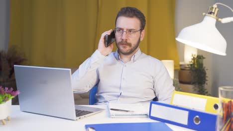 trabajador de oficina en casa hombre habla por teléfono en cualificaciones de gestión.