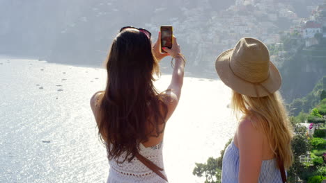 dos amigos tomando una foto de la costa de amalfi
