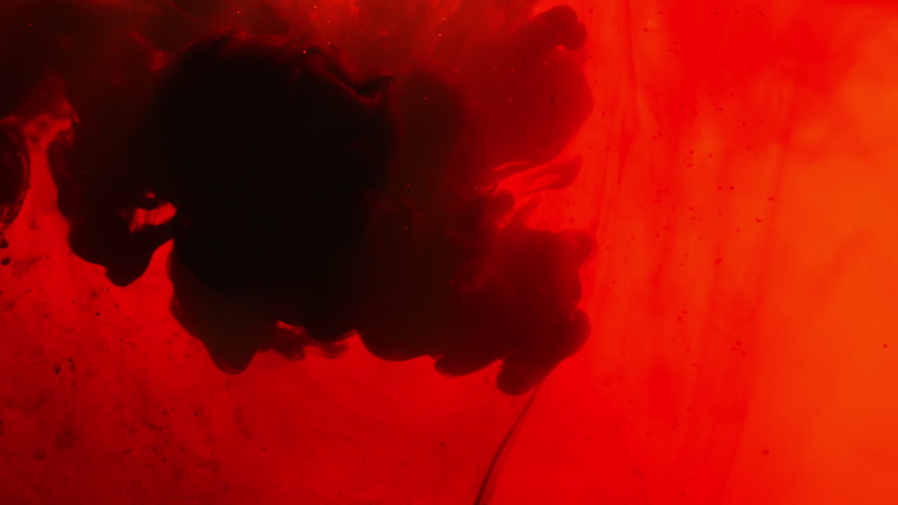 빨간색과 검은색 페인트 또는 염료가 색 배경에 물에 떨어지면 회전하는 다채로운 연기 배경을 만니다.