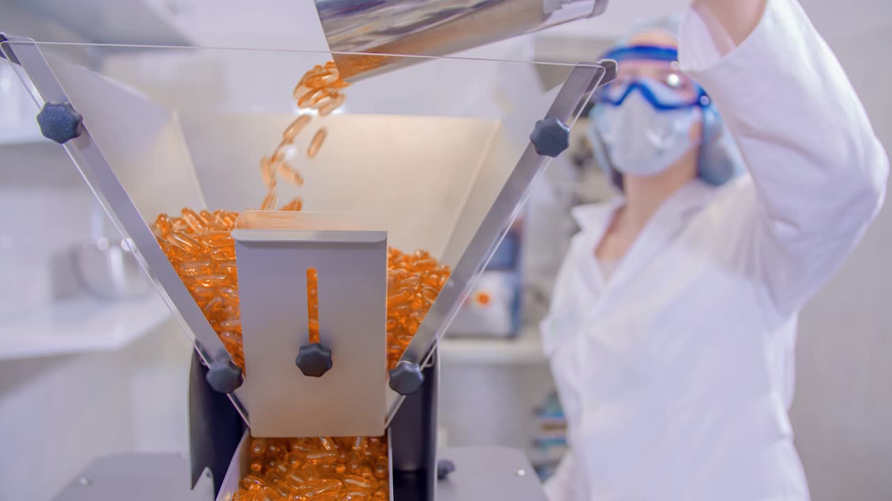 약국 약 캡슐 알약이 삐져나와 작업자에 의해 기계에 채워집니다.