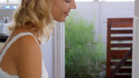una rubia linda usando una computadora portátil en la cocina