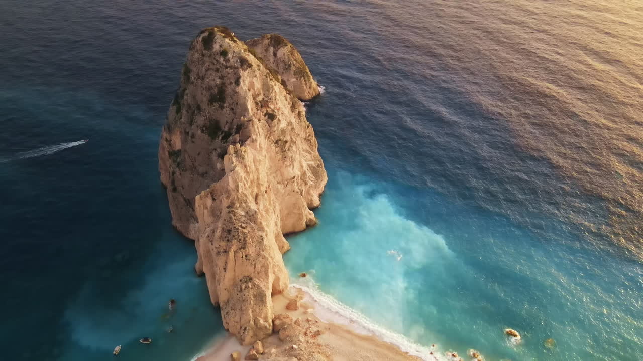 Aerial drone view of the Ionian Sea coast of Zakynthos, Greece. Rocky ridge, floating boat, blue water. Sunset