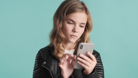 teenage caucasian girl in leather jacket using her smartphone.