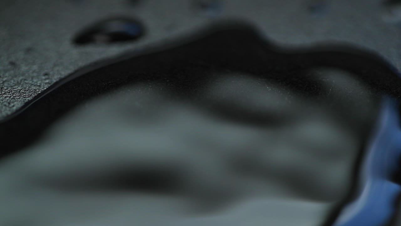 매크로 카메라를 닫을 때 슬로우 모션으로 물 방울 캡처 보드니 hladinu a pomalu se rozpustí do stran on dark backgound plate on light reflection