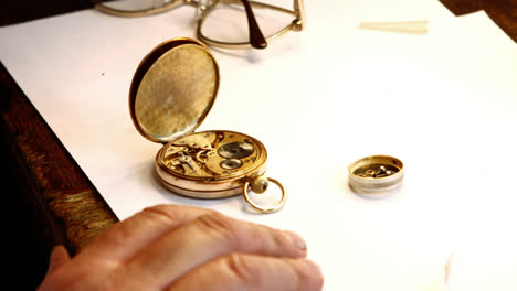 hands of horologist repairing a pocket watch