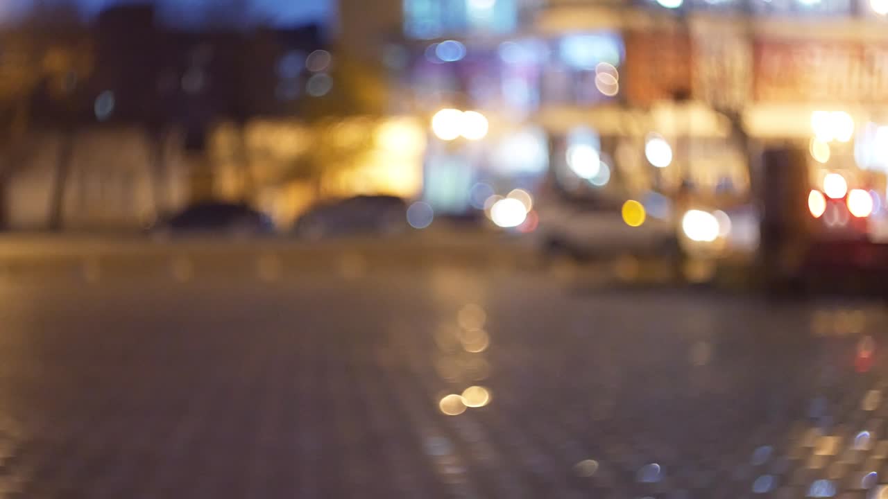 bokeh anamórfico cinematográfico con calle de la ciudad nocturna a la luz de faros y linternas