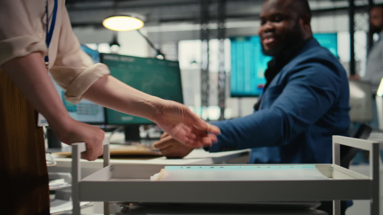 Professional archivist uses rolling trolley to transport documents