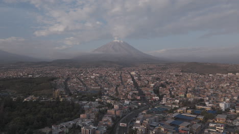 forwards moving drone shot above arequipa peru with view on the mountain near sunset time with clouds in the sky log