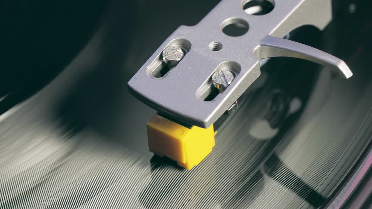 비닐 플레이어 턴테이블: 회전하는 비닐 레코드의 조각, 바늘을 클로즈업으로 가진 스타일러스, 바늘과 비닐 판을 클로스업으로 멈추는.