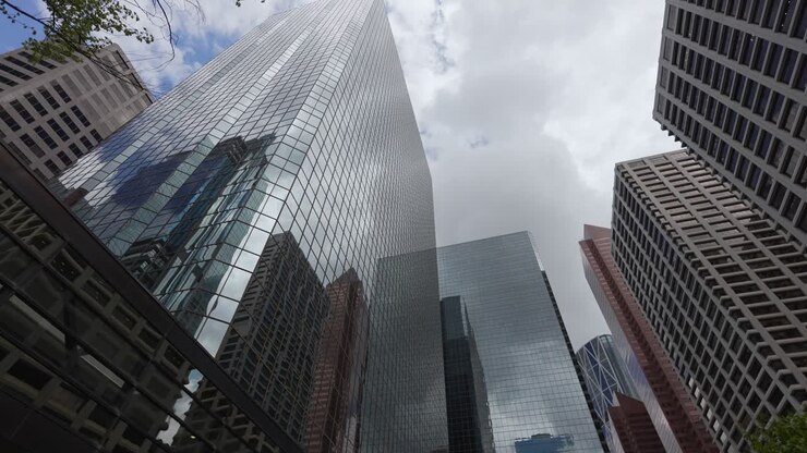 Grattacieli del centro di Calgary con facciate in vetro e cemento che svettano verso un cielo nuvoloso